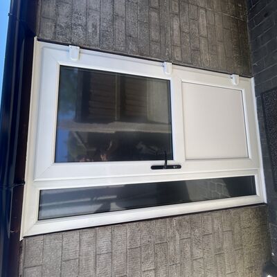 Newly fitted white uPVC back door with glass panel, side window and black handle.